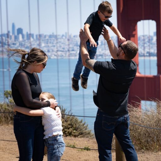 Family playing together near Golden Gate Bridge during a San Francisco vacation photoshoot