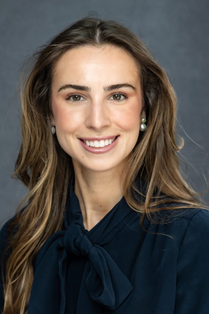 Professional woman in glasses and white blazer during a natural light headshot session in San Francisco