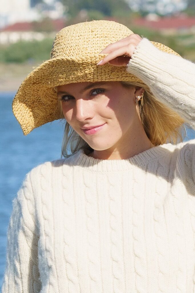 Outdoor lifestyle headshot of a woman in a straw hat and cream sweater, taken by Chris Conner Photography in San Francisco